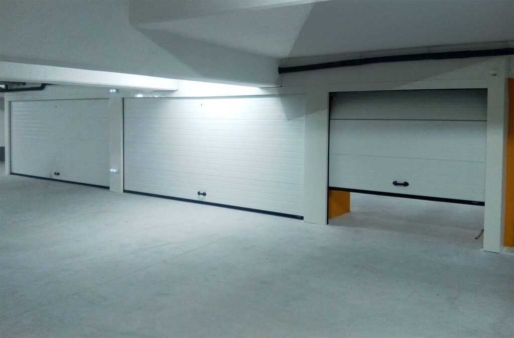 Intérieur de garage avec porte de garage sectionnelle rainurée blanche La Toulousaine