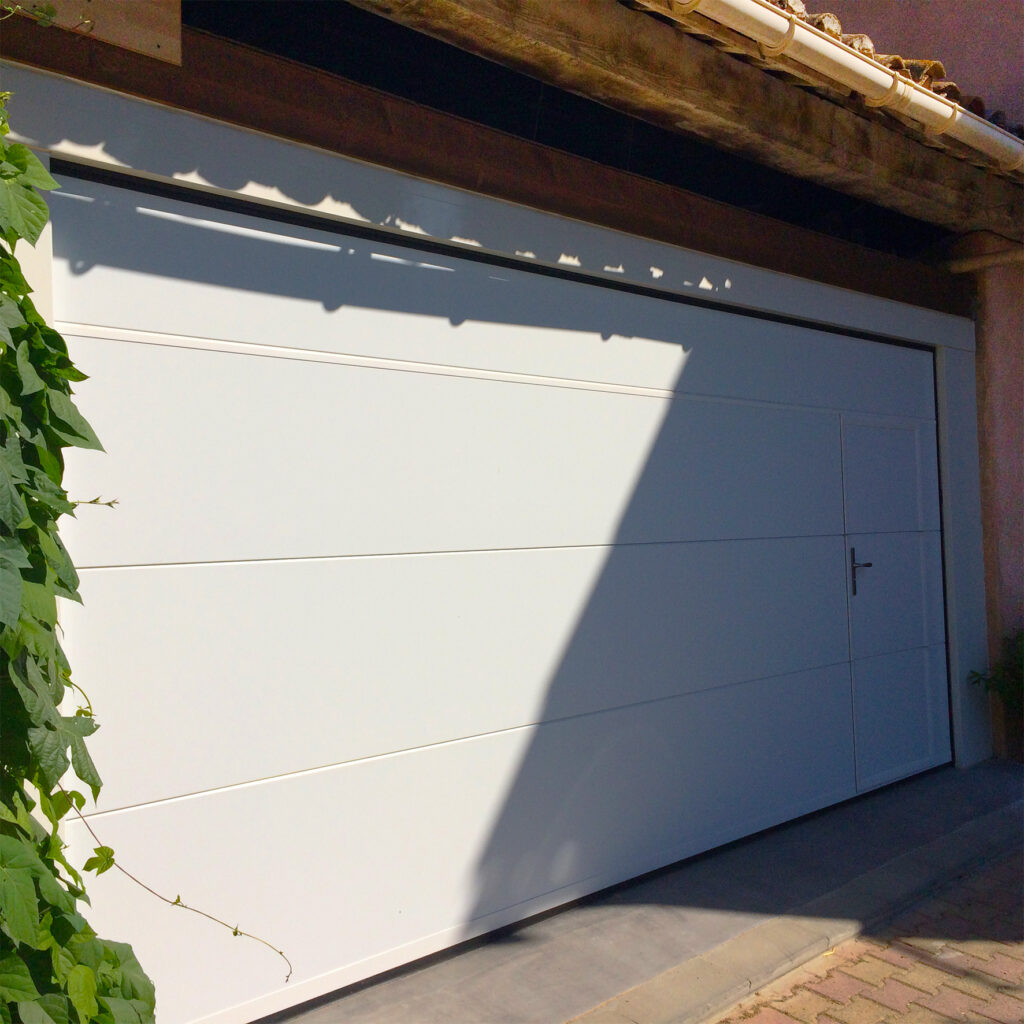 Porte de garage sectionnelle extérieure blanche avec portillon La Toulousaine